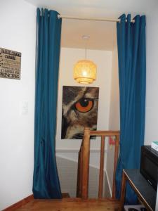 una cortina azul en una habitación con una foto de un ojo en Gîte 4 pers avec option sauna- Classé 3 étoiles- Sud charente, 