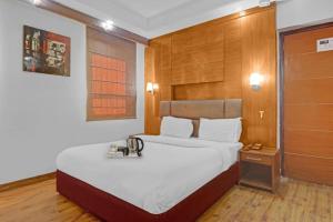 a bedroom with a large bed with a wooden headboard at The Royal Galaxy - Sec. 12 Dwarka Metro Station in New Delhi
