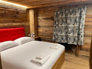 1 dormitorio con 1 cama en una habitación de madera en CASA VITTORIA, en Gignod
