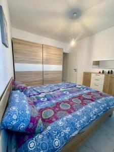 - une chambre avec un grand lit et une couette colorée dans l'établissement 2 Bedroom apartment close to the beach, à San Pawl il-Baħar