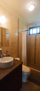een badkamer met een wastafel, een toilet en een douche bij La Rivera Chamba in Loja