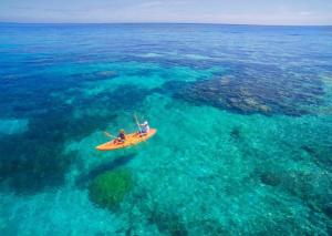 a person on a yellow kayak in the ocean at S@fe Landing Lodge in Nacula Island