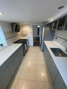 a large kitchen with white counter tops and appliances at Warwick House - Stunning house with terrace and sea views, sleeps 11 in Worthing