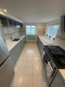 a large kitchen with blue cabinets and a stove at Warwick House - Stunning house with terrace and sea views, sleeps 11 in Worthing