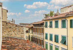 um grupo de edifícios com persianas verdes em Haggi’s Residence em Florença