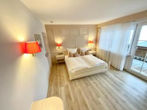 ein kleines Schlafzimmer mit einem Bett und einem Fenster in der Unterkunft Hotel JMS Holiday Allgäu in Oberreute