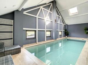una piscina en una habitación con paredes azules en The Lodge Ardenne, en Tailles