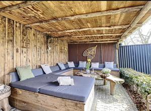 un patio con un sofá azul y una mesa en The Lodge Ardenne, en Tailles