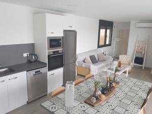 a kitchen and living room with a table in a room at Casa con piscina y jardin privado OASIS DE DOLORS in Puig-Gros