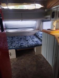 a small room with a bed in the back of an rv at Map of Africa Luxury Caravan with private bathroom with sea view in Wilderness