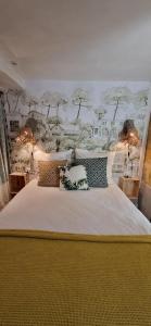 a bedroom with a large white bed with pillows at Iris la fleuriste in Talence