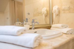 bagno con lavandino, specchio e asciugamani di Villa Rustica a Polańczyk