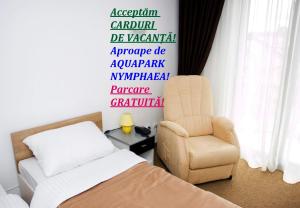 ein Schlafzimmer mit einem Bett und einem Stuhl in der Unterkunft RHC Royal Hotel in Oradea