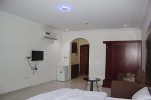 1 dormitorio con cama, sofá y TV en جوان سويت للشقق المخدومة en Yeda
