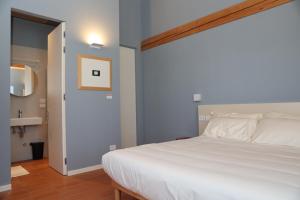 a bedroom with a white bed and a mirror at Locanda Lingua in Rimini