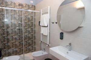 ein Badezimmer mit einem Waschbecken, einem WC und einem Spiegel in der Unterkunft Locanda Lingua in Rimini