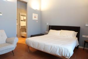 Bett in einem Zimmer mit einem Stuhl und einem Bett sidx sidx sidx sidx in der Unterkunft Locanda Lingua in Rimini