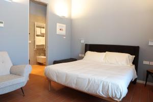a bed in a room with a chair and a bed sidx sidx sidx at Locanda Lingua in Rimini