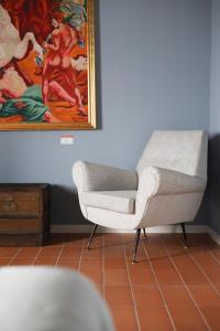una sedia in una stanza con un dipinto sul muro di Locanda Lingua a Rimini