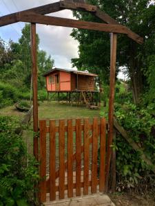 BIVAQUE hospedaje في تيغري: بوابة خشبية لكابينة بها سياج