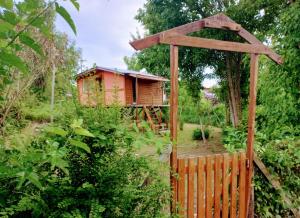 un jardín con una valla de madera y una casa en el árbol en BIVAQUE hospedaje en Tigre