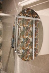 リミニにあるLocanda Linguaの花の壁紙を用いたバスルーム(円形鏡付)