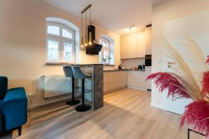a kitchen with a counter and a bar in a room at Apartament Smile - z prywatnym monitorowanym parkingiem by SpaceApart in Jelenia Góra