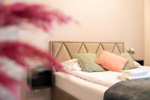 a bedroom with a bed with pillows and a tv at Apartament Smile - z prywatnym monitorowanym parkingiem by SpaceApart in Jelenia Góra