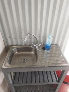 a sink with a bottle of soap on a shelf at Map of Africa Luxury Caravan with private bathroom with sea view in Wilderness