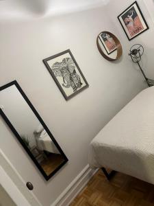 a bedroom with a mirror and pictures on the wall at Two bedroom excellent location in Queens