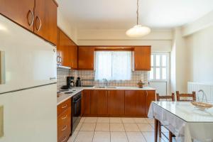 una cucina con armadi in legno e frigorifero bianco di Vintage Family Comfort By Greece Apartment a Aigio