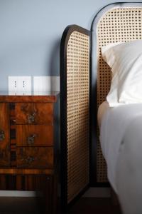 a bedroom with a bed and a dresser with a white pillow at Locanda Lingua in Rimini +1 photo