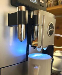 Ferienwohnung Alpenglühen - mit Sauna & Frühstück في شليرزيه: وجود ماكينة قهوة على كاونتر مع كوب