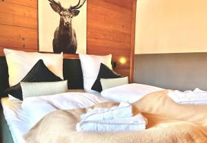 Ferienwohnung Alpenglühen - mit Sauna & Frühstück في شليرزيه: سريرين في غرفة مع صورة غزلان على الحائط