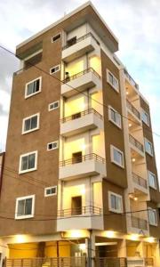 a tall apartment building with lights on at Reef Hotel in Hyderabad