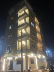 a tall building with lights on it at night at Reef Hotel in Hyderabad