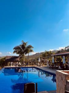 einen Pool mit Tischen und Stühlen in einem Resort in der Unterkunft Hotel Campestre Palmas del Zamorano in San Gil