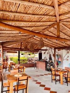 einen Pavillon mit Holztischen und -stühlen und einem Weihnachtsbaum in der Unterkunft Hotel Campestre Palmas del Zamorano in San Gil