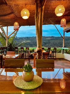 ein Restaurant mit Tischen und Stühlen und einem Topf auf einem Tisch in der Unterkunft Hotel Campestre Palmas del Zamorano in San Gil