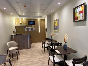 a waiting room with tables and chairs and a tv at Hostel Apart in Dar el Beïda