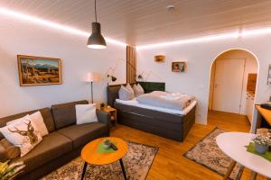ein Wohnzimmer mit Sofa und Bett in der Unterkunft Stube Elli mit Oberstaufen Plus Karte in Oberstaufen