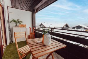 einem Holztisch mit Topfpflanze auf dem Balkon in der Unterkunft Stube Elli mit Oberstaufen Plus Karte in Oberstaufen