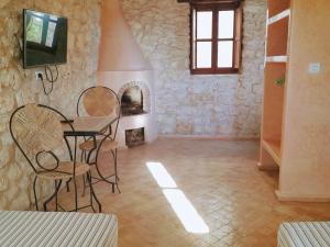 Zimmer mit einem Tisch, Stühlen und einem Kamin in der Unterkunft Riad Mamy Wababi in Essaouira