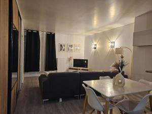 un soggiorno con divano e tavolo di Magnifique appartement au bord de la Seine avec parking a Villeneuve-la-Garenne