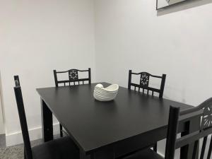 uma mesa preta com duas cadeiras e uma tigela. em 07 St Andrews em Lytham St Annes