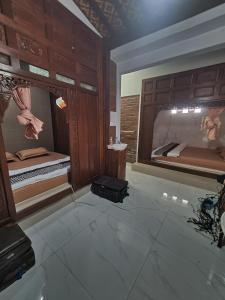 ein Zimmer mit 2 Betten und einem Koffer auf dem Boden in der Unterkunft Joglo Wismono Prambanan in Prambanan