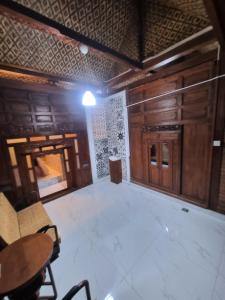 ein leeres Zimmer mit Holzwänden sowie einem Tisch und Stühlen in der Unterkunft Joglo Wismono Prambanan in Prambanan