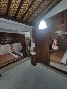 Zimmer mit 2 Betten und einer Lampe an der Wand in der Unterkunft Joglo Wismono Prambanan in Prambanan