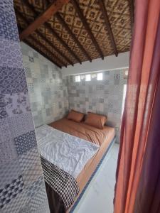 ein kleines Bett in einem kleinen Zimmer mit in der Unterkunft Joglo Wismono Prambanan in Prambanan