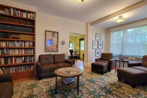 a living room with couches and a table and books at Bluemoon Vacation Rentals - Anne Hathaway House in Ashland